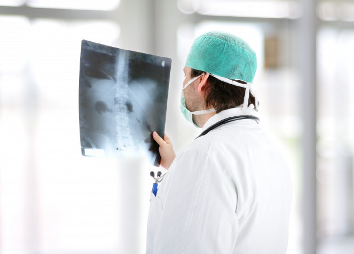 medical-doctor-analysing-x-ray-image-handheld-standing-office-desk_21730-10724