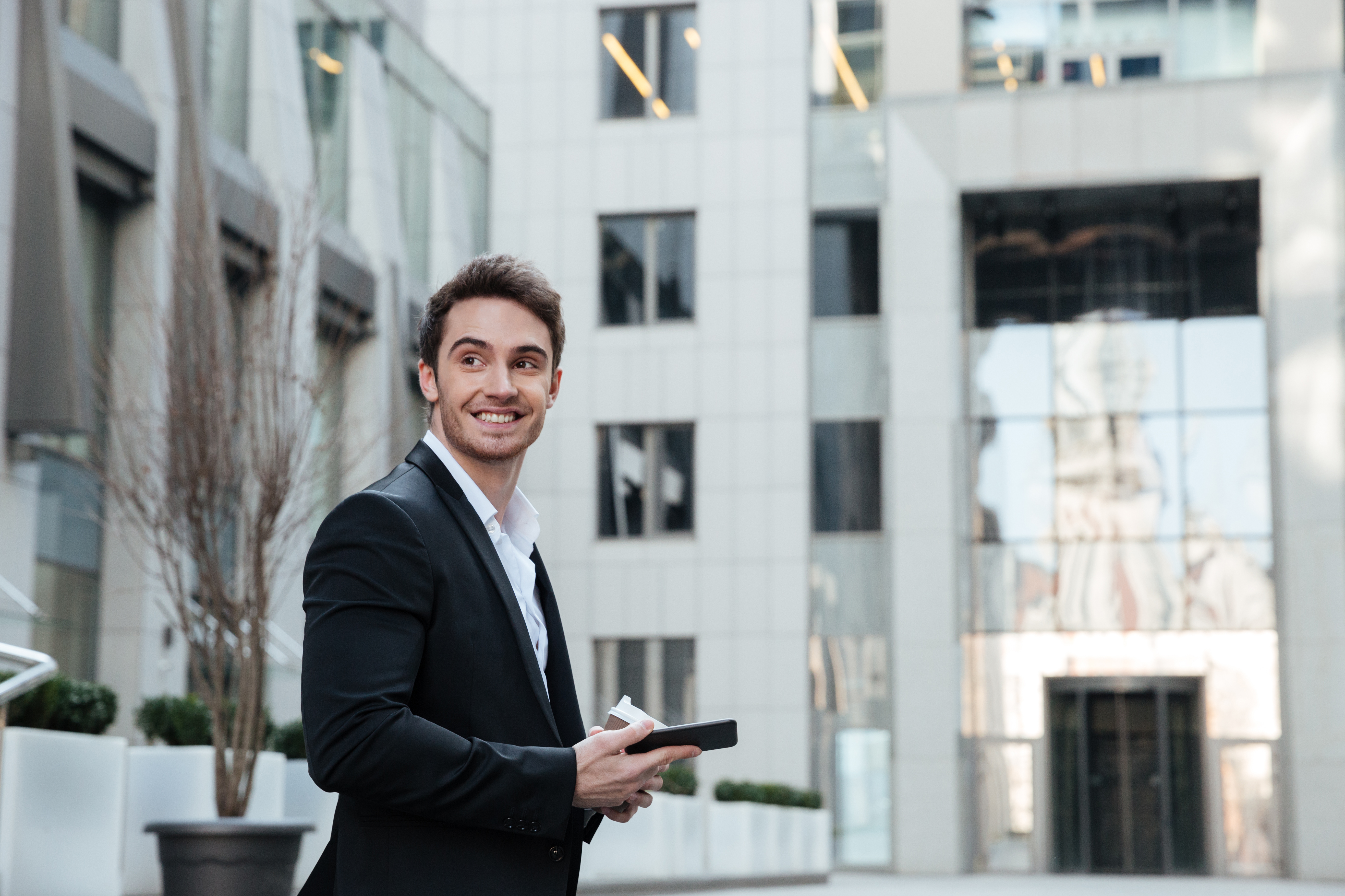 Man looking away while going upstairs with coffee