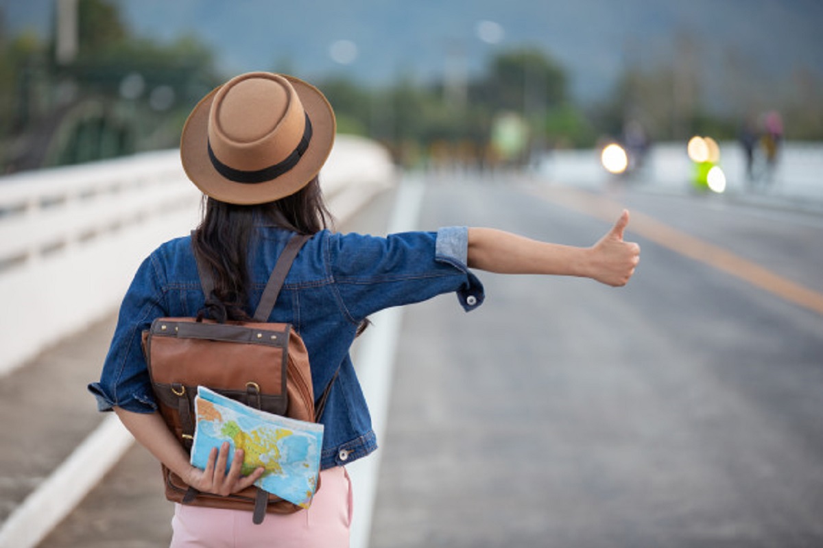 female-travelers-waving-cars-road_1150-7424