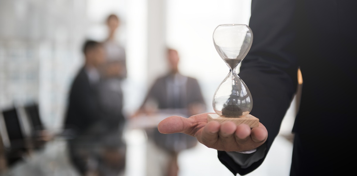 Businessman holding an hour glass, signifies the importance of being on time